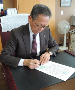 宣言書に署名する遠藤村長